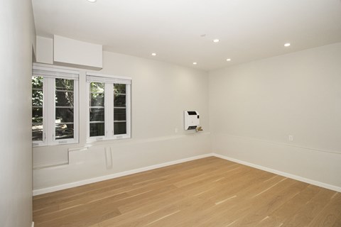 A room with a window and a white wall.