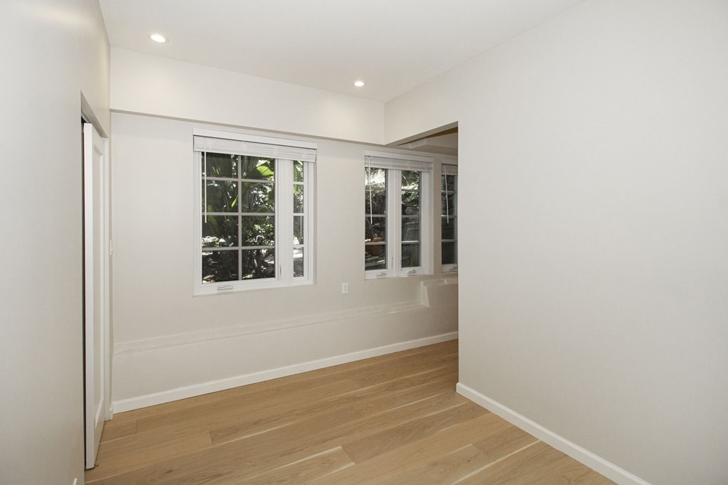 A room with a window and wooden flooring.