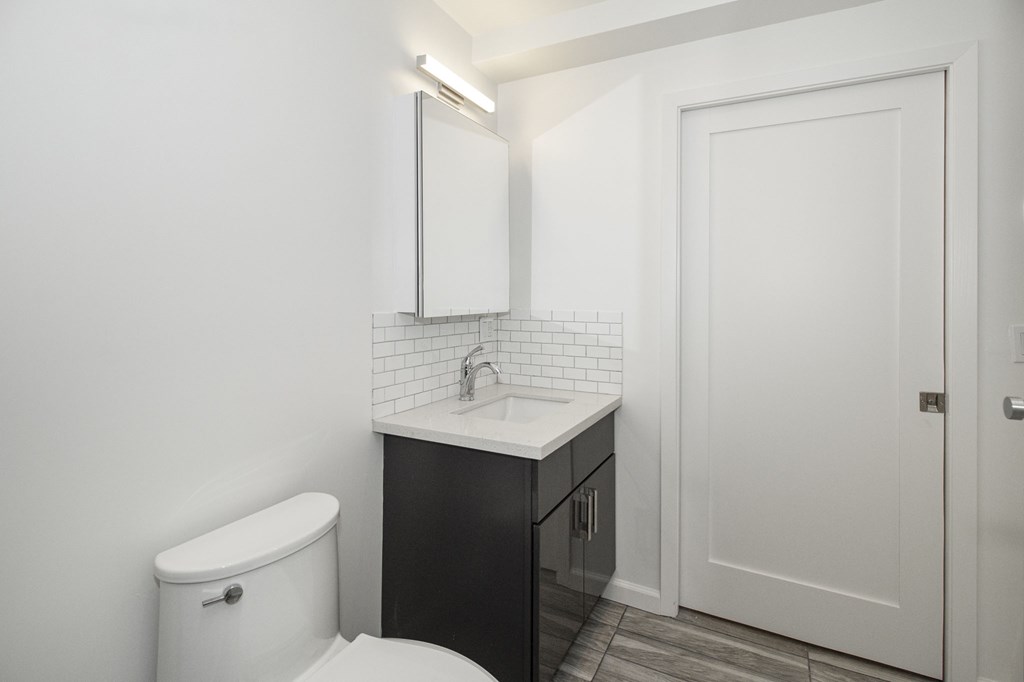 A white toilet sits next to a sink in a small bathroom.