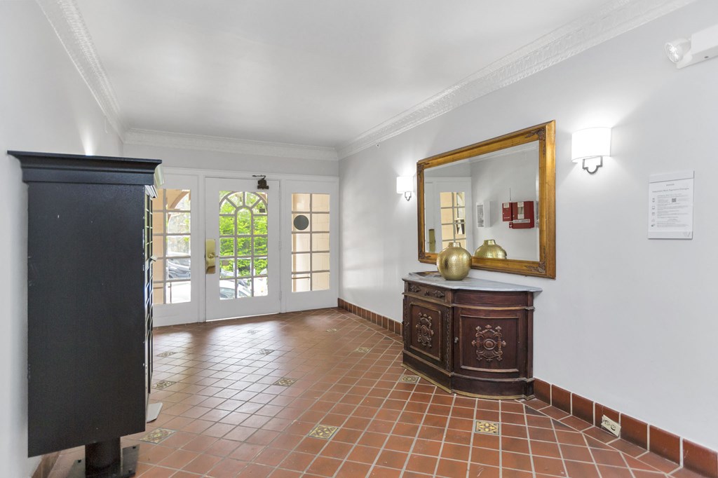 A room with a brown cabinet and a mirror on the wall.