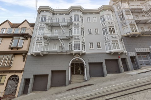 A large, multi-story building with a flat roof and a balcony on the second floor.