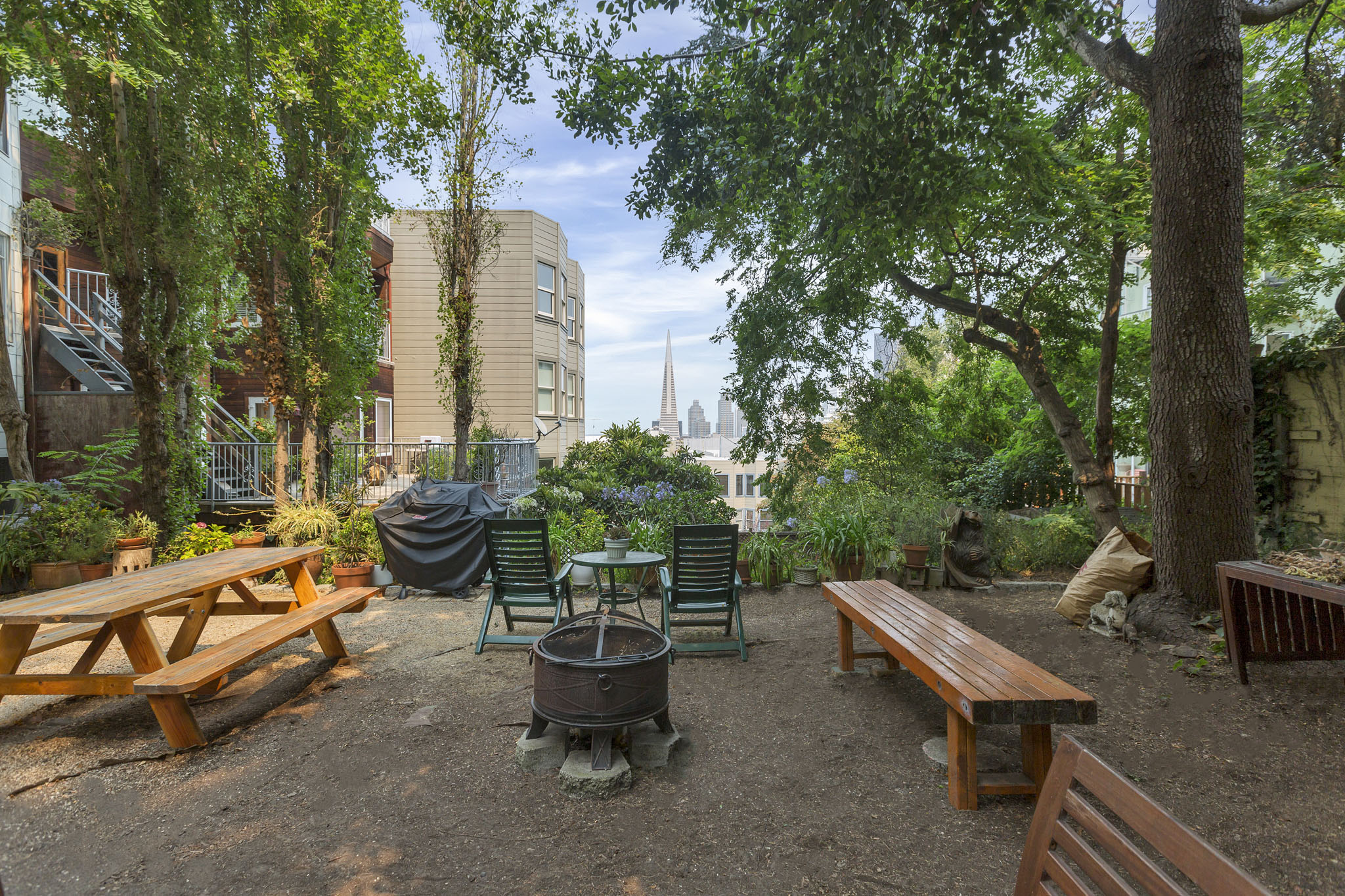 A backyard with a picnic table and a fire pit.