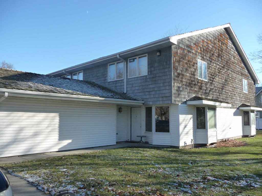the front of a white house with a gray roof