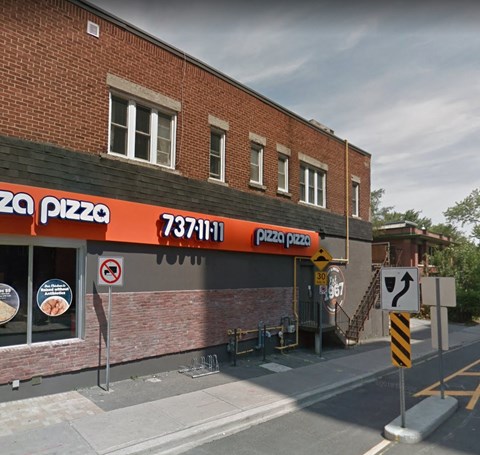 a pizza restaurant on the corner of a city street