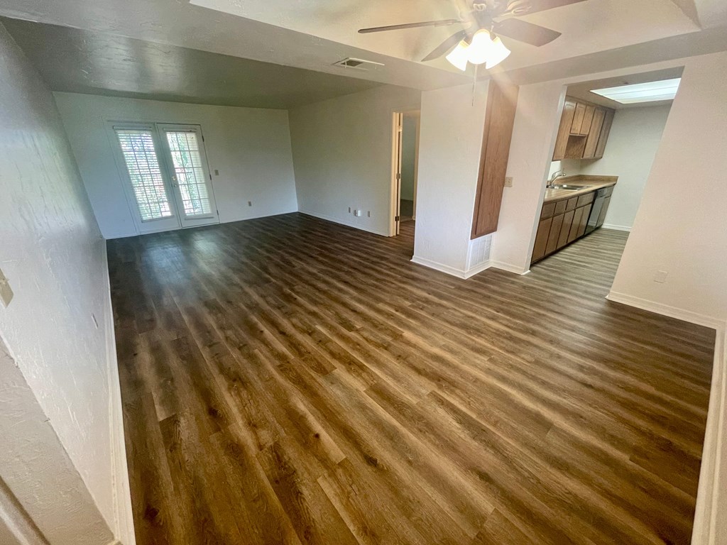 an empty living room with a hard wood floor