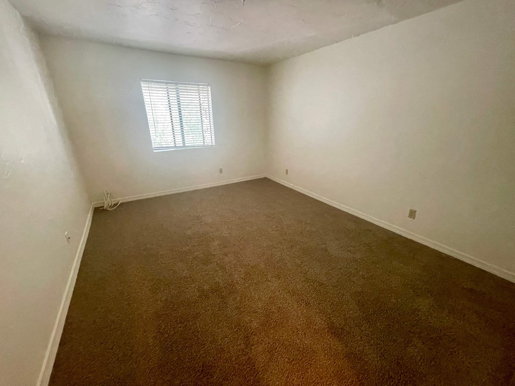 an empty room with white walls and a window