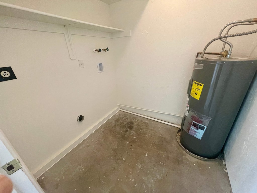 a room with a water heater in the corner of a room