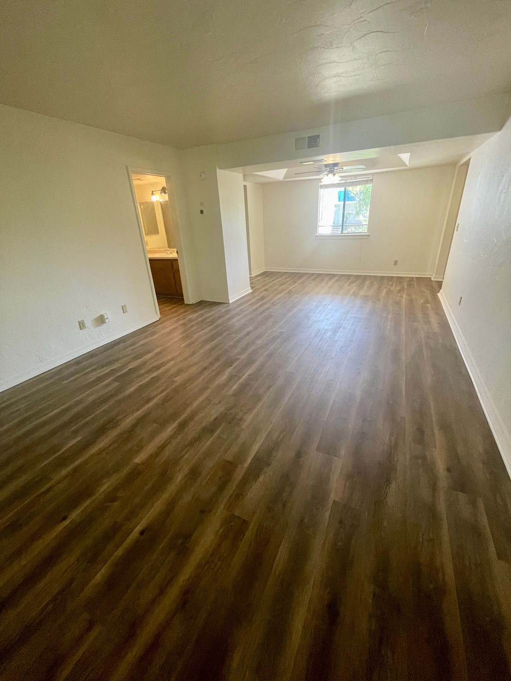 an empty living room with wooden floors in a house