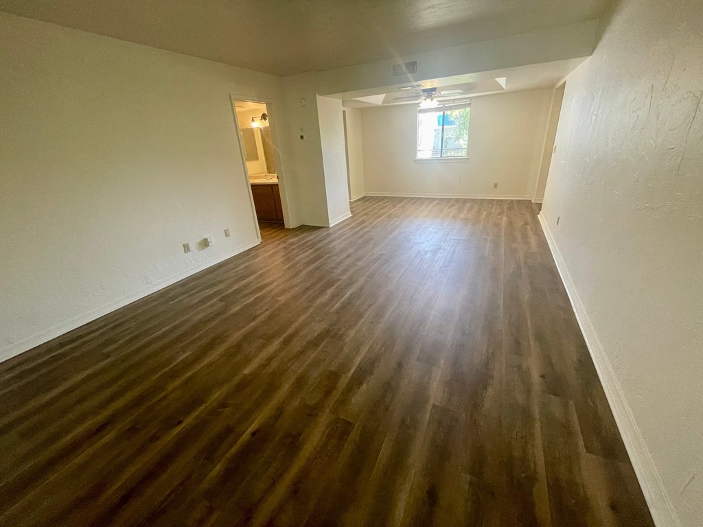 an empty living room with wood flooring in a house