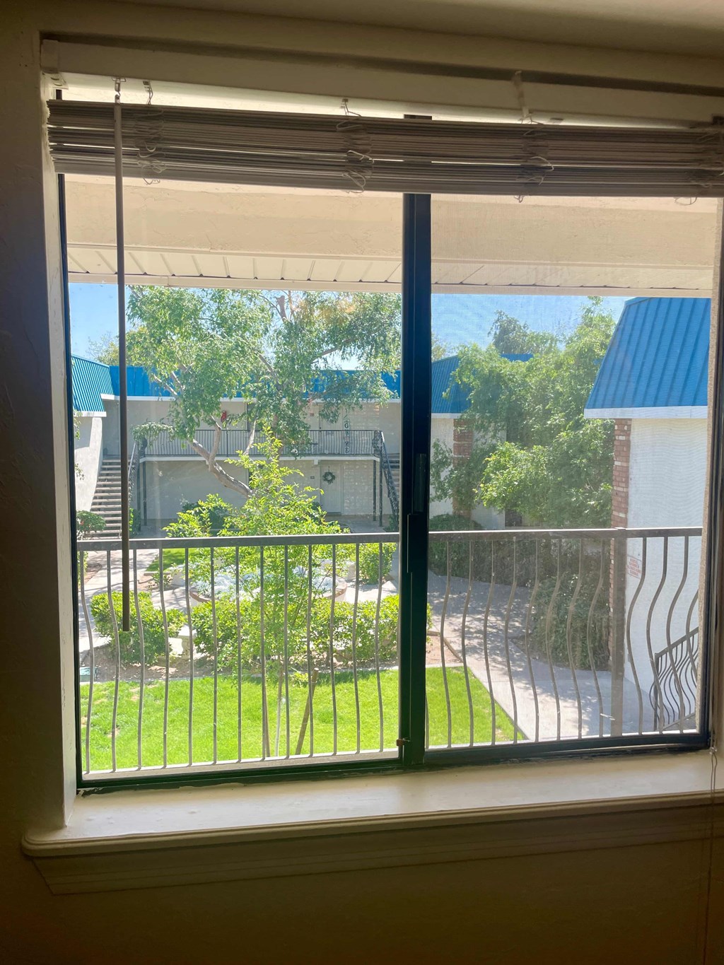 a large window with a view of a garden and a balcony