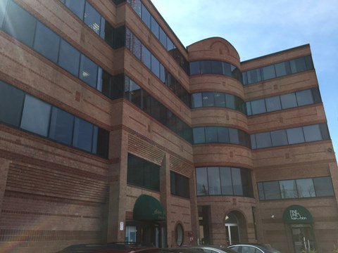 A large brown building with a green awning and a sign that says "The Lounge".