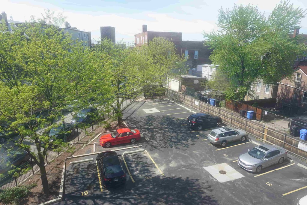 an aerial view of a parking lot with cars and trees