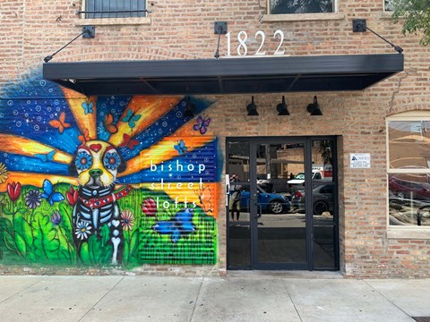 the front of a building with a colorful mural and a door