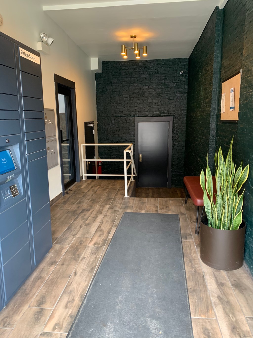 a lobby with a black door and a potted plant