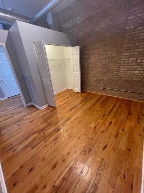 an empty room with wooden floors and a brick wall