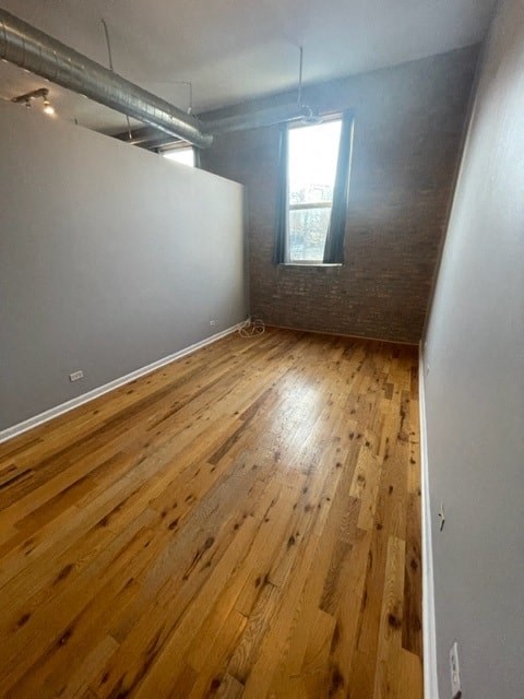 an empty room with a wood floor and a window
