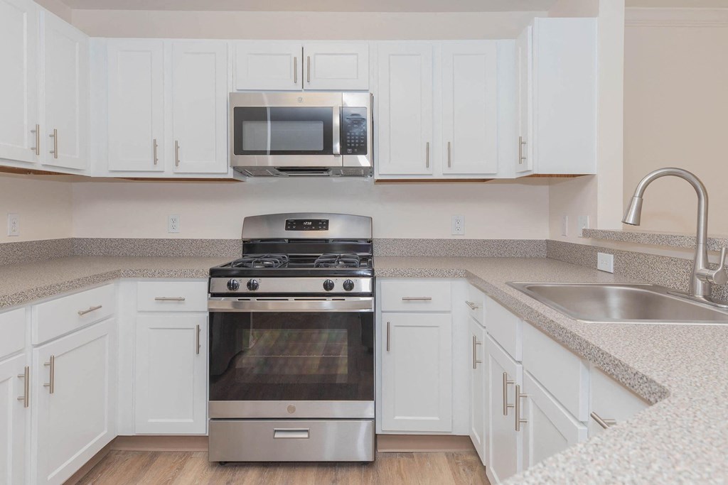 a kitchen with stainless steel appliances and white cabinets