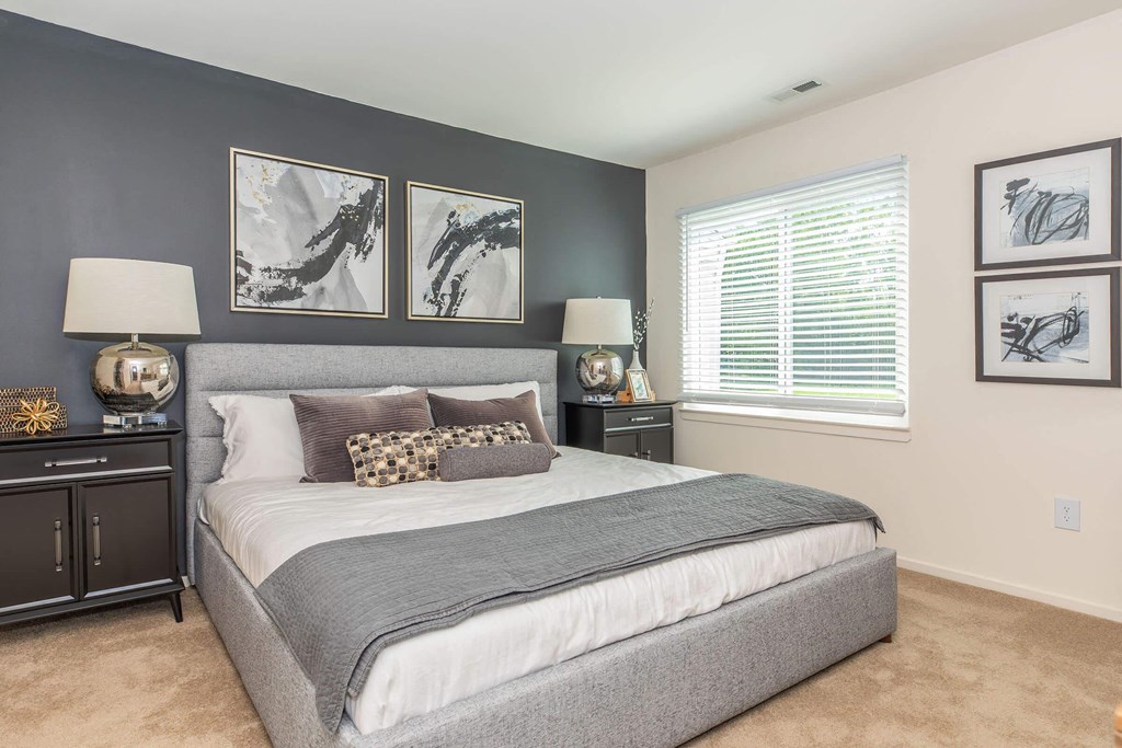 a bedroom with a bed and pictures on the wall