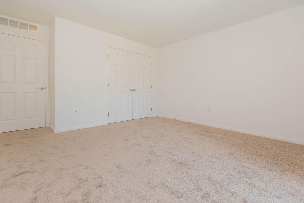 a bedroom with a carpeted floor and white walls
