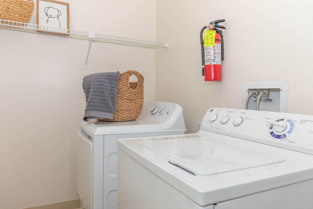 a white washer and dryer in a laundry room with a basket on top