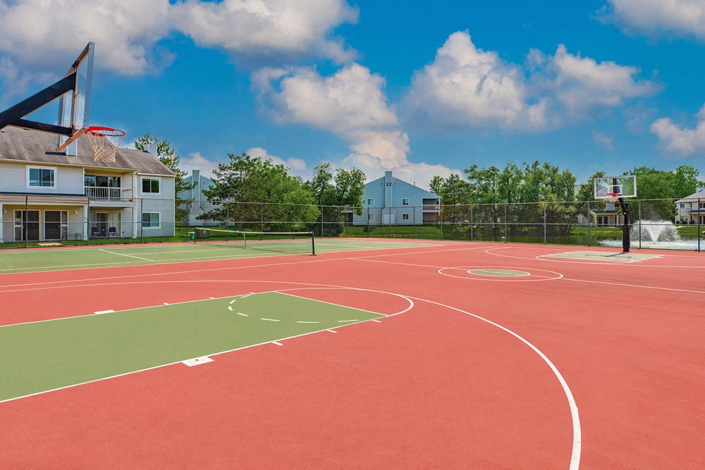 a basketball court with apartments in the background