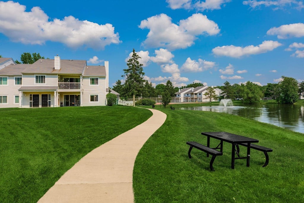 a path leading to a building with a river in the background
