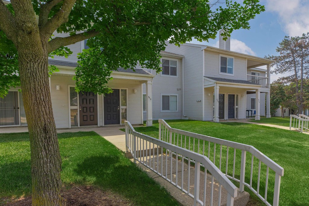 a white house with a white fence and a tree