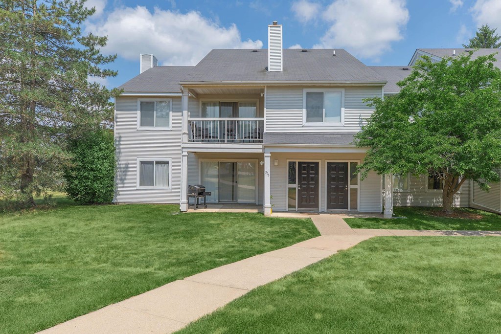 a white house with a lawn and a sidewalk in front of it