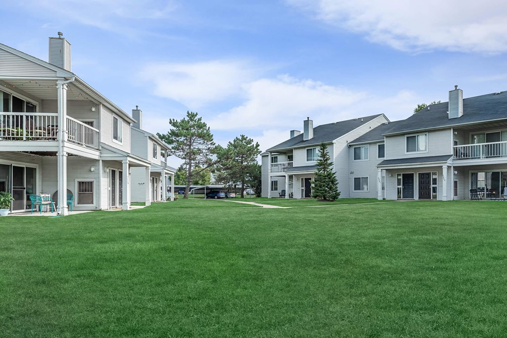 a large lawn in front of a group of houses