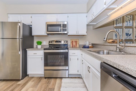 a kitchen with stainless steel appliances and white cabinets