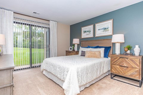 a bedroom with a bed and a sliding glass door