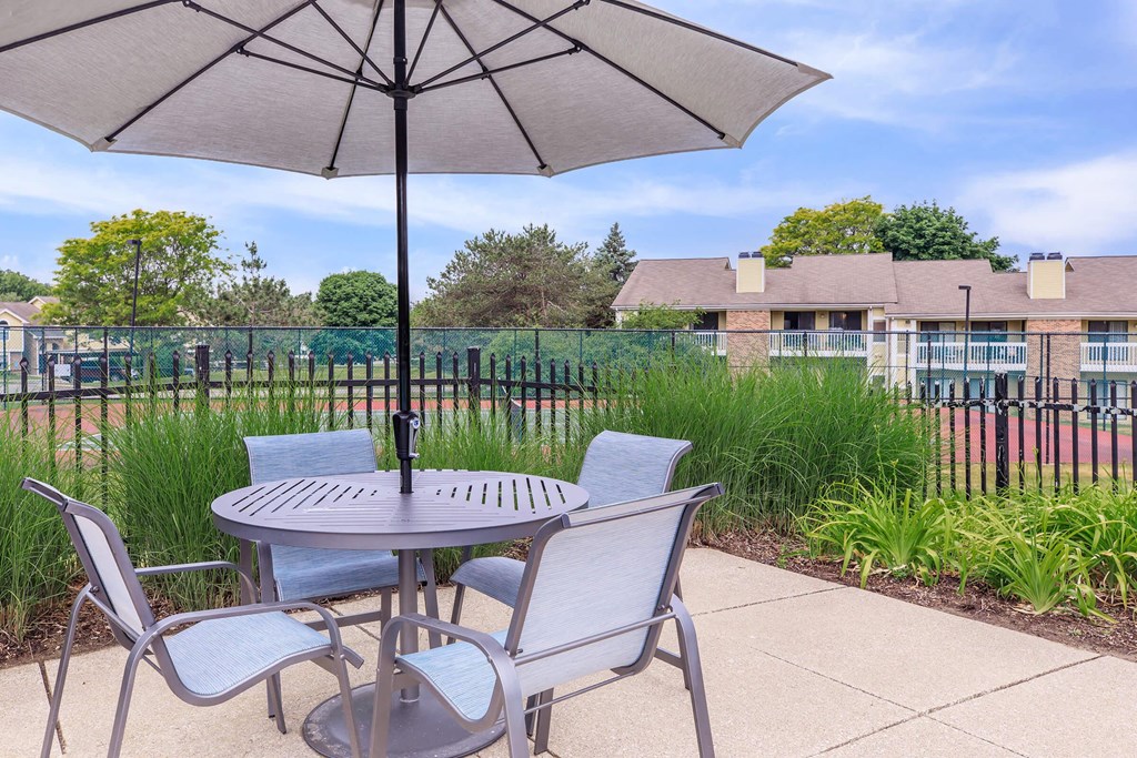 a patio with a table and chairs with an umbrella