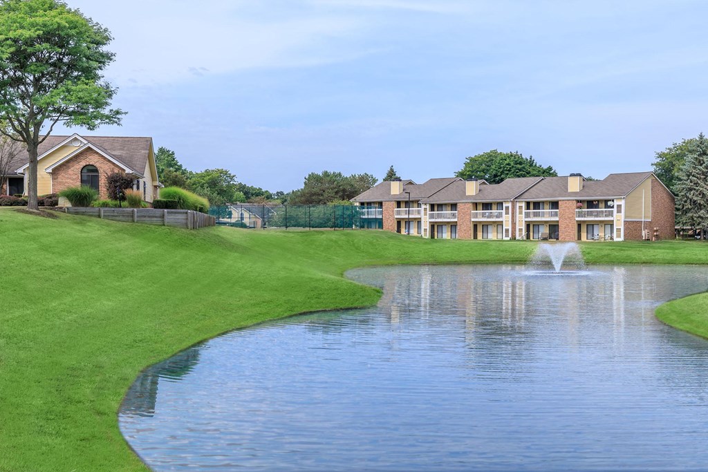 a large pond with a fountain in front of a building