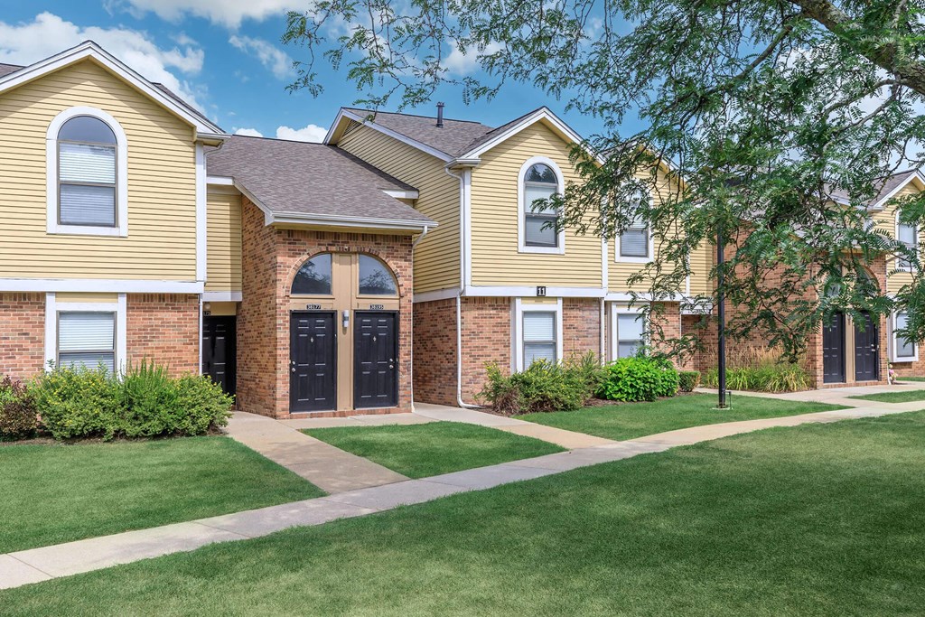 front view of two story house with walkway and grass and trees