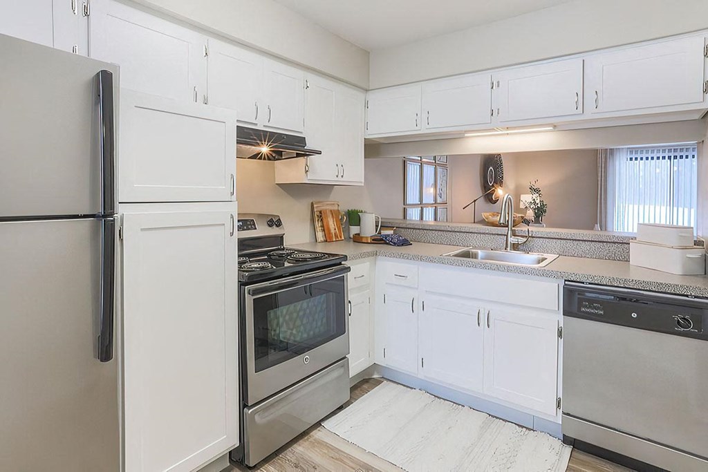 a kitchen with stainless steel appliances and white cabinets