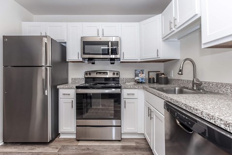 a kitchen with stainless steel appliances and white cabinets