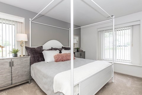 a bedroom with a white bed and a mirrored closet