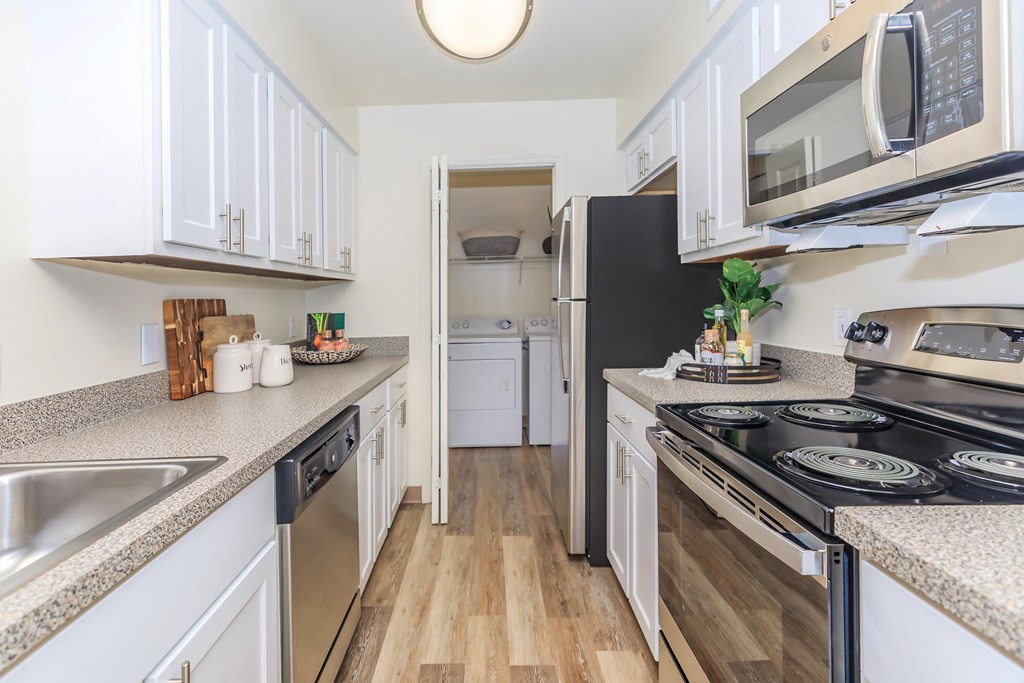 a kitchen with white cabinets and stainless steel appliances