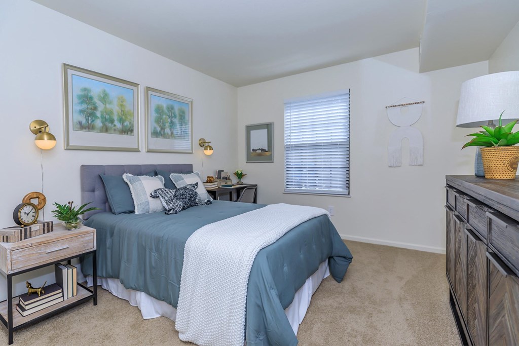 a bedroom with a bed and a dresser and a window