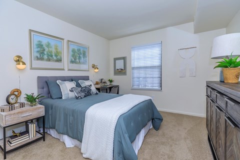 a bedroom with a bed and a dresser and a window