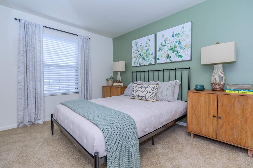 a bedroom with a bed and a dresser and a window