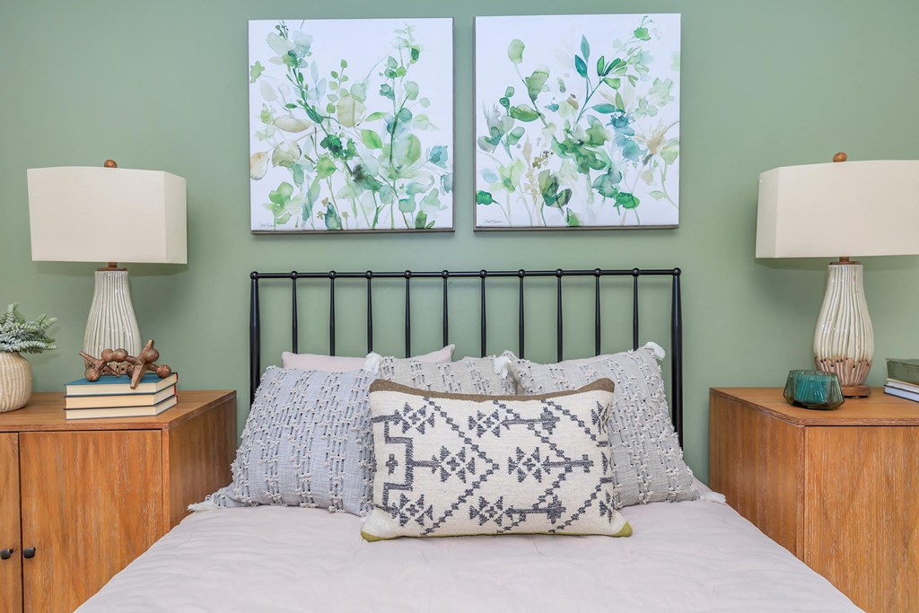 a bedroom with two paintings on the wall above a bed