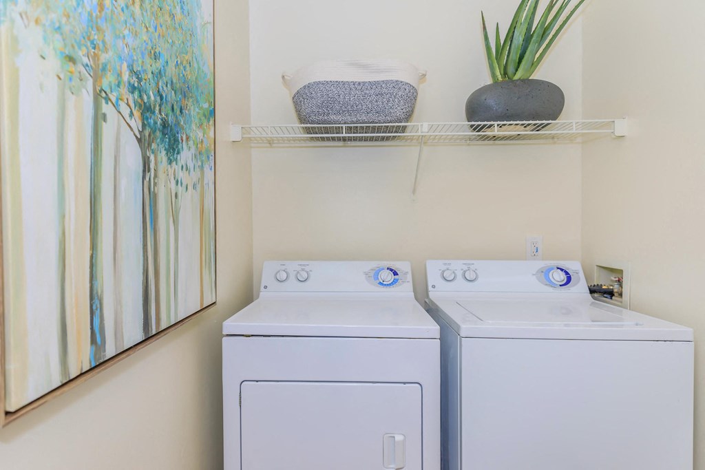 a white washer and dryer in a laundry room with a mirror