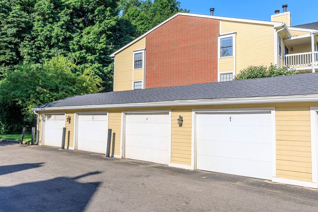 a garage with a row of white doors in front of a house