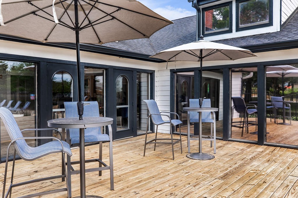 a patio with tables and chairs and umbrellas