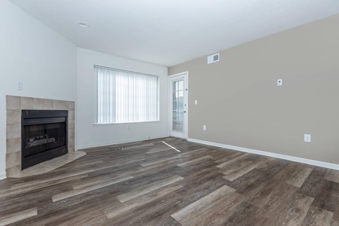 a living room with a fireplace and wooden floors