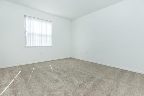 an empty room with carpet and a window