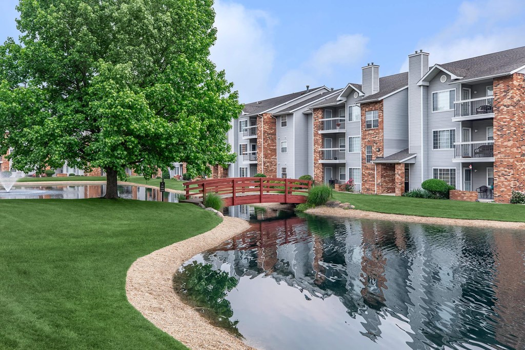 an apartment building with a bridge over a pond