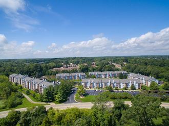 an aerial view of an apartment complex with trees and a blue sky