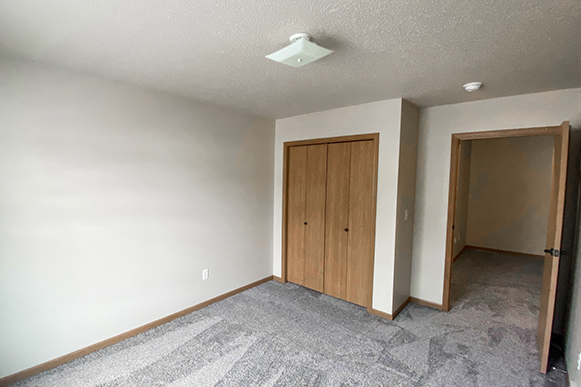 Guest bedroom in Osgood Townhome with closet, located upstairs, with carpet flooring